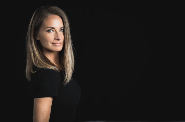 istock Beautiful middle aged blond woman on black background 1141685705