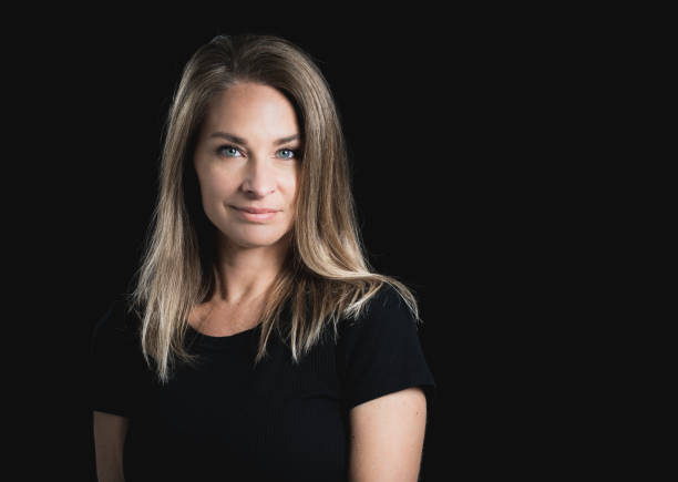 istock Beautiful middle aged blond woman on black background 1141685713