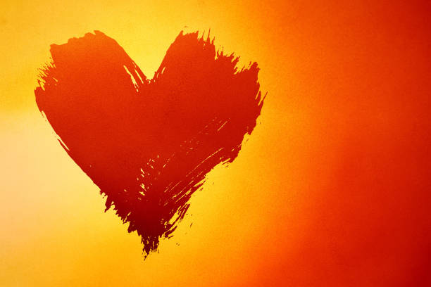 Abstract colorful background with brushstroke painted grunge heart over red and yellow gradient noise grain texture with copy space