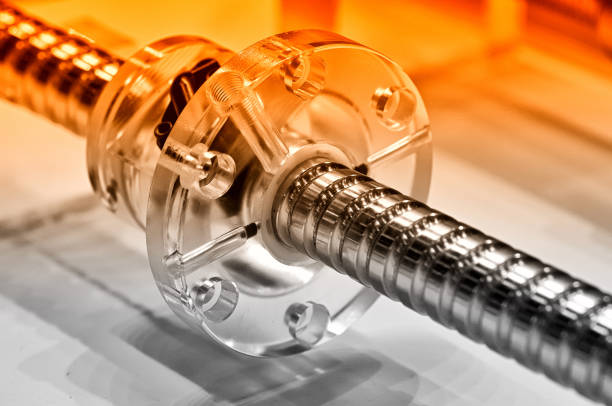 Steel rod with a screw thread and a plastic round detail. Red toned, small depth of field. Close up