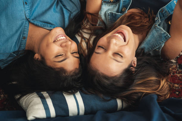 istock Two friends lying on the carpet and laughing 1141687091