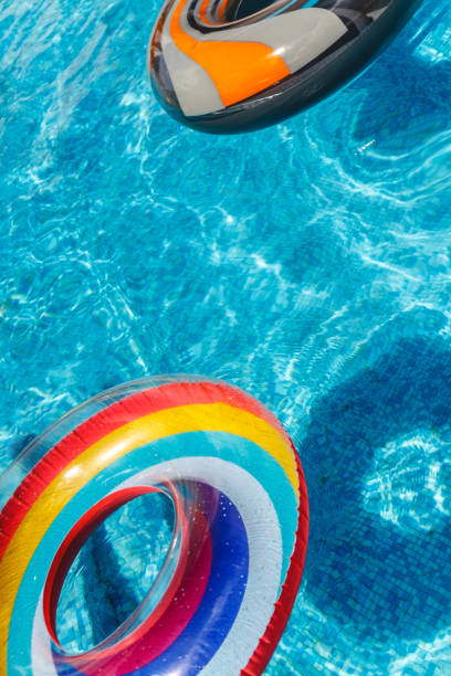 las actividades inflables de agua círculos de la tuba flotan en el agua en la piscina. concepto, diversión, verano alegre y relajación. - water park resort swimming pool public swimming pool beach ball fotografías e imágenes de stock