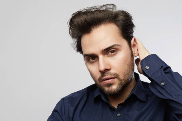 istock Handsome hispanic trendy man posing isolated on a white empty background and looking camera 1141691002