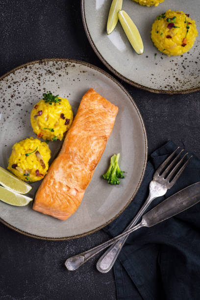 istock Grilled Salmon Fillet with Saffron Risotto on Dark Background 1141692551