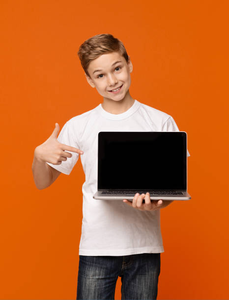 istock Happy smiling boy pointing at laptop computer 1141692652