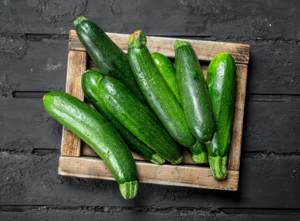istock Green zucchini in wooden tray. 1141692702