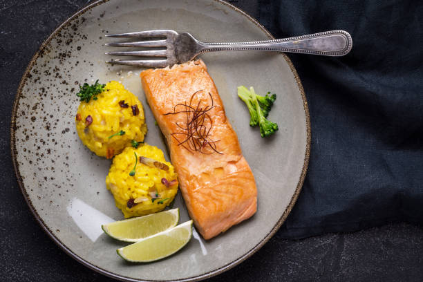 istock Grilled Salmon Fillet with Saffron Risotto on Dark Background 1141692713