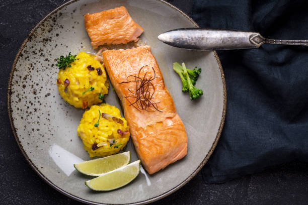 istock Grilled Salmon Fillet with Saffron Risotto on Dark Background 1141692749