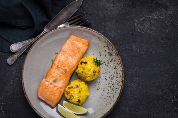 istock Grilled Salmon Fillet with Saffron Risotto on Dark Background 1141692884