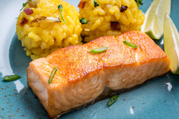 istock Grilled Salmon Fillet with Saffron Risotto on Dark Background 1141692920