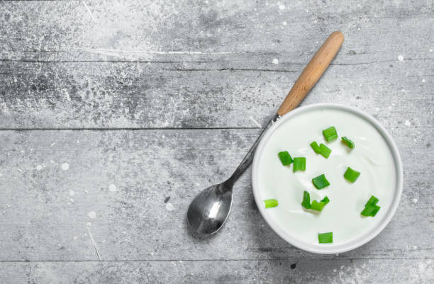 istock Sour cream in bowl with green onions. 1141692929