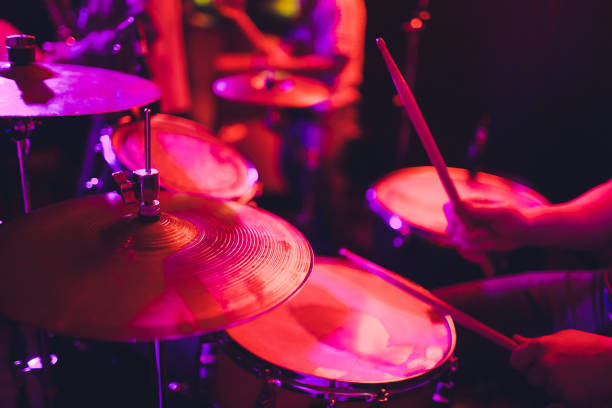 istock man plays musical percussion instrument with sticks closeup on a black background, a musical concept with the working drum, beautiful lighting on the stage. 1141693731