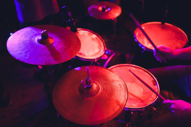 istock man plays musical percussion instrument with sticks closeup on a black background, a musical concept with the working drum, beautiful lighting on the stage. 1141693746
