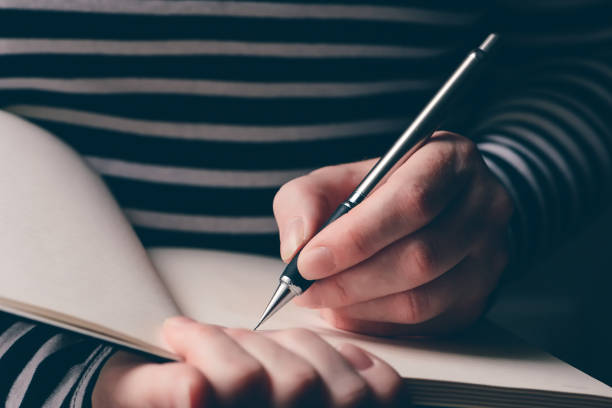 istock Left-handed woman writing diary 1141693853
