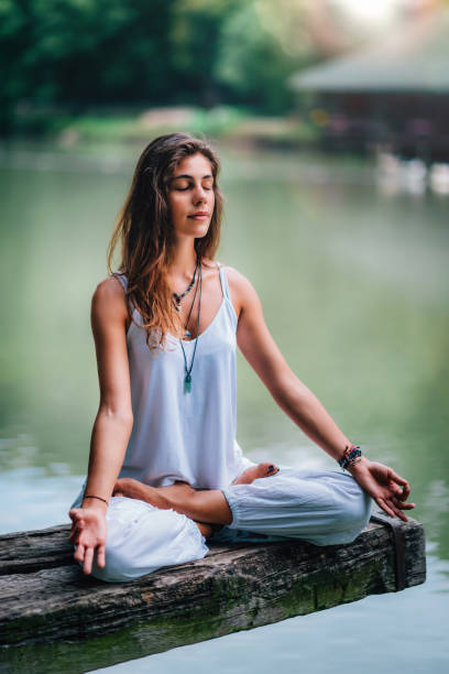 istock Woman Meditating by the Lake 1141694436