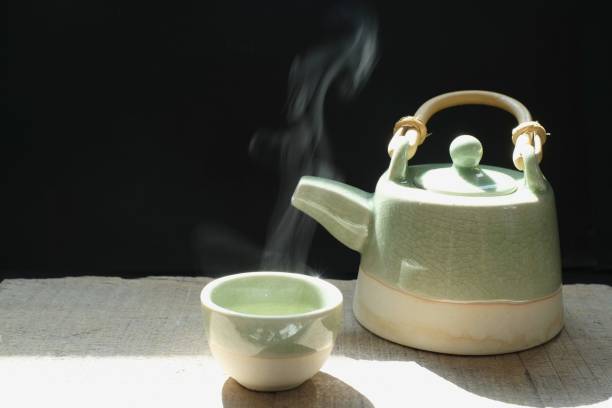 istock hot tea with smoke in cup on black background 1141696021