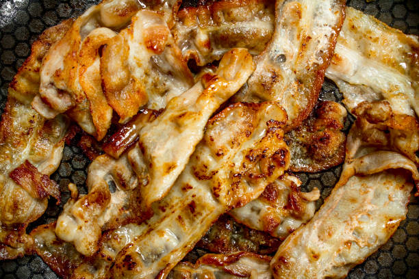 istock Fried bacon in a frying pan. 1141696170