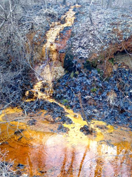istock Orange polluted stream runs into orange creek 1141697943