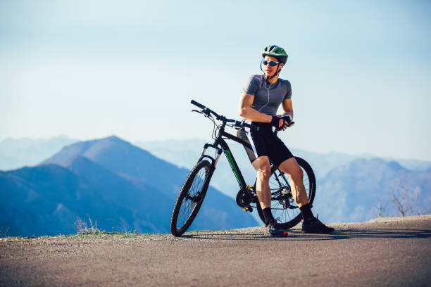 atlético deportista ciclista de pie con bicicleta disfrutando de hermosas vistas. - mountain biking extreme sports cycling bicycle fotografías e imágenes de stock