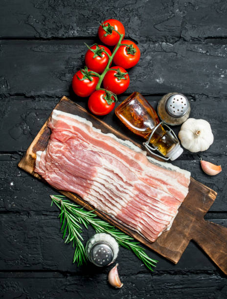 istock Raw bacon with tomatoes and spices. 1141700187