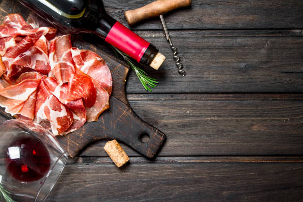 prosciutto spagnolo con un bicchiere di vino rosso. - cork tops foto e immagini stock