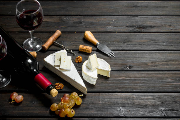 istock Brie cheese with red wine, nuts and grapes. 1141701335