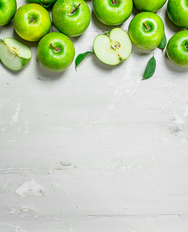 Green fresh apples. On white rustic background .