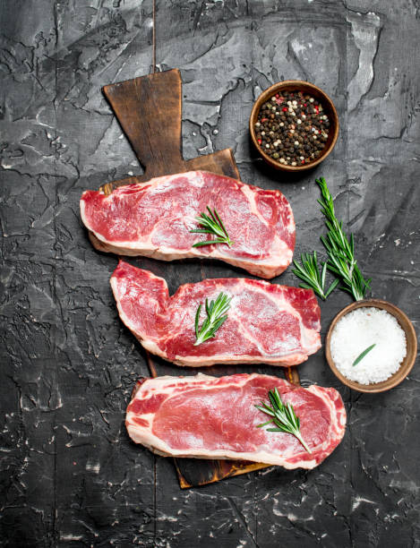 istock Raw marbled beef steaks with salt and spices. 1141701634