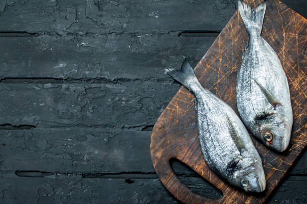 istock Raw sea fish dorado on a cutting Board. 1141702084