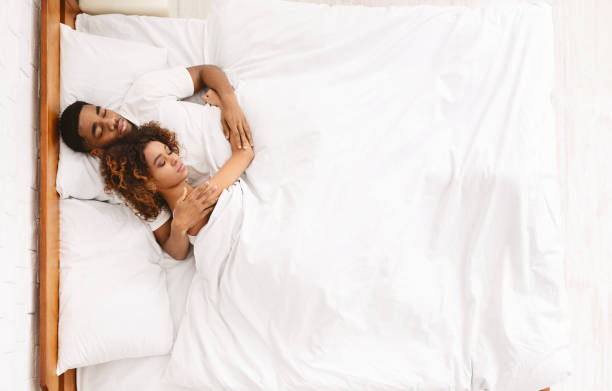 istock Loving couple sleeping in bed and hugging 1141702281
