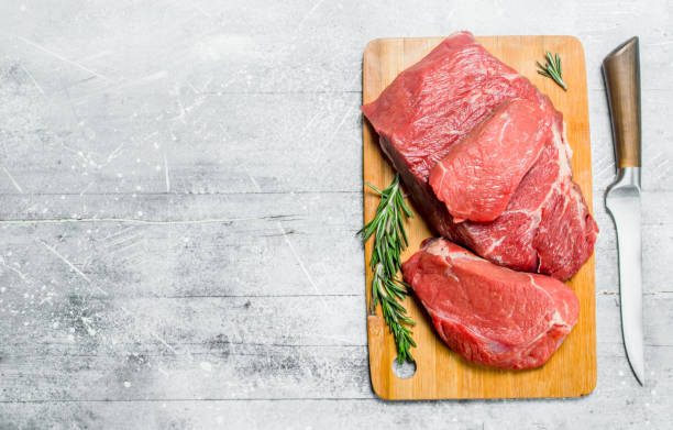 istock Raw meat.Pieces of fresh beef with rosemary branches. 1141704296