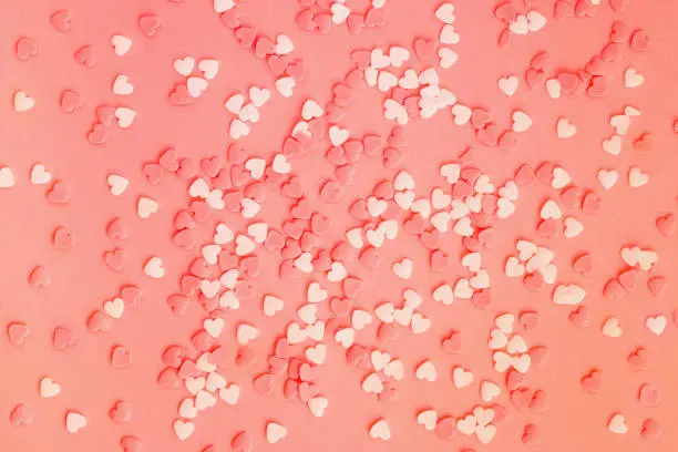 Photo of Coral background with white and coral little hearts.