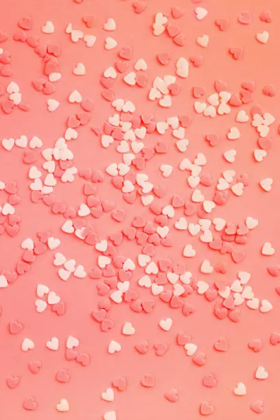 Photo of Coral background with white and coral little hearts.