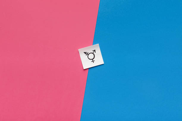Transgender symbol on pink and blue background Choosing between genders. Sex selection. Paper card with transgender symbol on pink and blue background gender neutral photos stock pictures, royalty-free photos & images