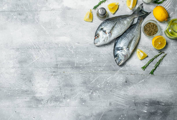 istock Raw sea fish with lemon wedges and garlic. 1141706085