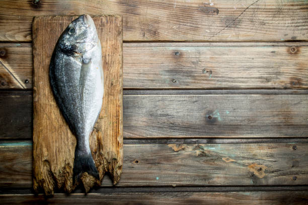 istock Raw sea fish dorado on a cutting Board. 1141707723