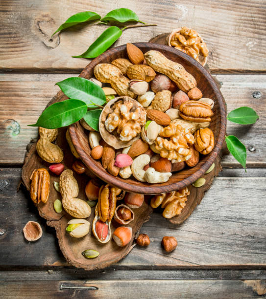istock Different kinds of nuts in bowl with leaves. 1141707887