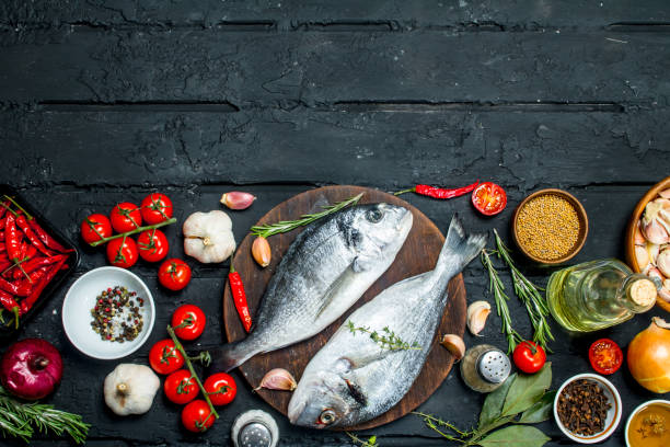 istock Raw sea fish dorado with spices and vegetables. 1141708611