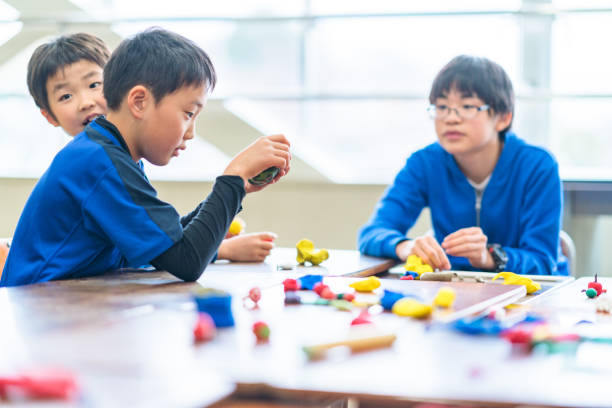 ученики начальной школы учатся и играют в глину остроумия в классе - japanese culture japanese ethnicity japan toy стоковые фото и изображения