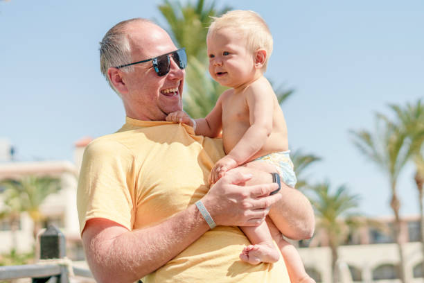 istock Happy father holding cheerful son during tropical vacation 1141714255