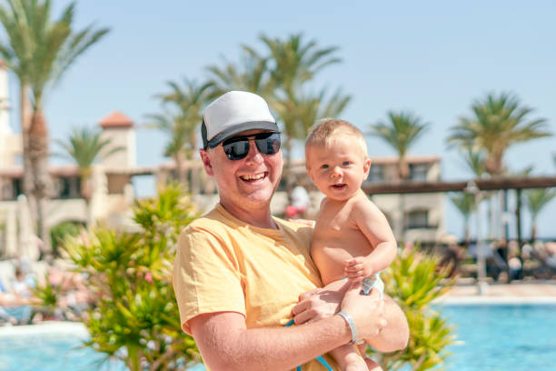 istock Happy father holding cheerful son during tropical vacation 1141714307