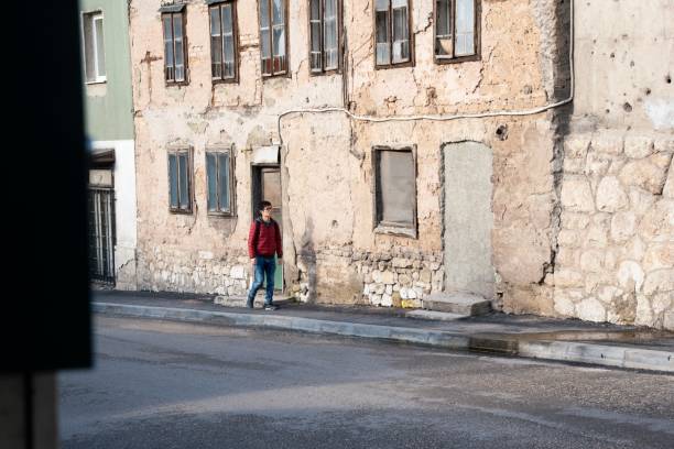 A mid adult man exploring old Sarajevo on foot on a late winter day.