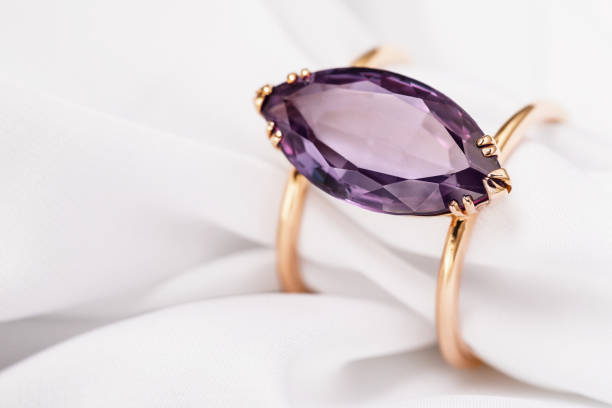 istock Gold ring with a large amethyst on silk fabric with copy space, close-up 1141716309