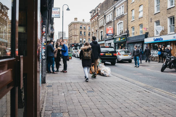 London, UK - April 6, 2019: People walking on Brick Lane, London. The street is the heart of the London's Bangladeshi-Sylheti community and is famous for its many curry houses.