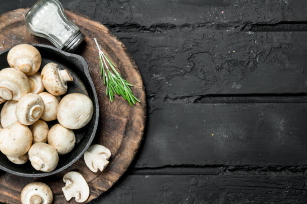 istock Fragrant mushrooms in pan on a cutting Board with salt. 1141728371
