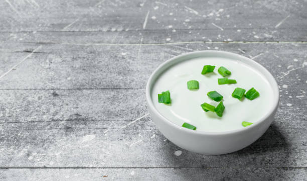 istock Sour cream in bowl with green onions. 1141729413