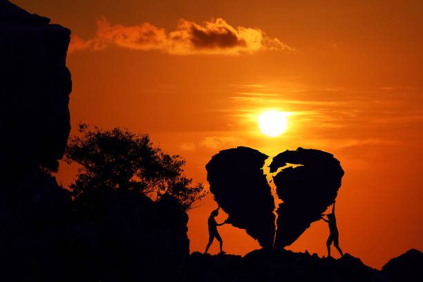 couples sur le rocher brisé de forme de coeur sur la montagne avec le coucher du soleil rouge de ciel. - heart shape stone red ecard photos et images de collection