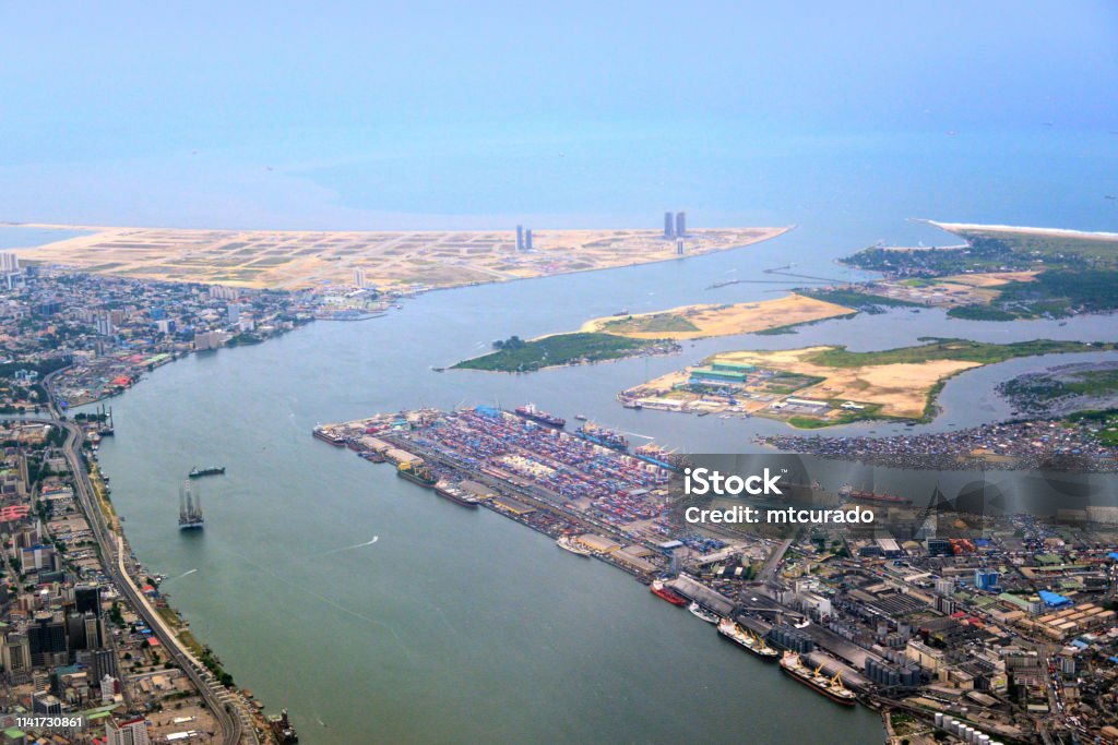 Lagos and its lagoon from the air - Lagos island business district, Victoria Island and Port of Lagos (Apapa Port), Nigeria Lagos, Nigeria: the city from the air - Lagos island business district, Victoria Island and Port of Lagos (Apapa Port, container terminal) - Eko Atlantic City land reclamation and Atlas Beach - Lagos Lagoon, Badagry Creek and Tarkwa Bay Nigeria Stock Photo