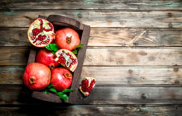 istock Ripe pomegranates with leaves in the box. 1141731170