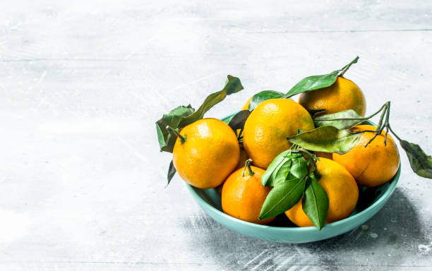 istock Fresh mandarins with leaves in a bowl. 1141731220